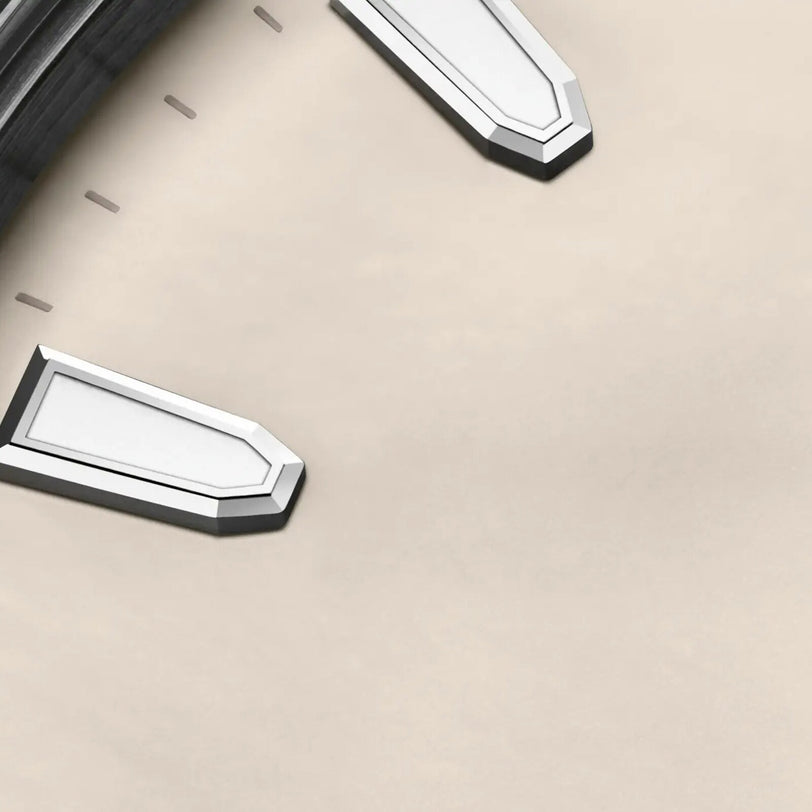 Close-up of the Oris Aquis Date watch face, featuring its bezel, marker, and metallic hour and minute hands on a beige background—showcasing Oris’s craftsmanship and sustainable values.