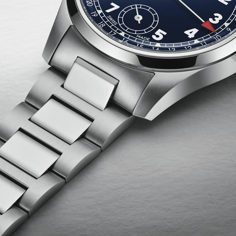 Close-up of the Oris Big Crown Pointer Date Calibre 403, a stainless steel watch with a midnight blue dial, white numerals, and metal link bracelet, showcased on a light textured surface.