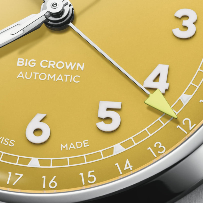 Close-up of the Oris Big Crown Pointer Date watch with a sunshine yellow dial, metallic hands, yellow arrowhead pointer at 4 o’clock, and “BIG CROWN AUTOMATIC” above center. Swiss-made automatic movement; numerals 3 to 7 shown.