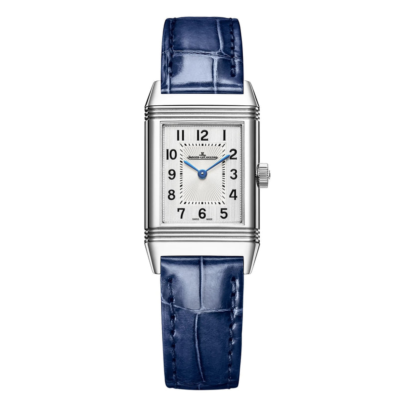 The Jaeger-LeCoultre Reverso Classic Small is a rectangular silver wristwatch with a blue leather strap, silver dial, black Arabic numerals, blue hands, art deco-style case lines, and a right-side crown.