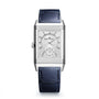 The Jaeger-LeCoultre Reverso Tribute Duoface Small Seconds is an Art Deco-style rectangular silver wristwatch with a white dial, day/night indicator, blue leather strap, and Duoface complication, shown on a white background.