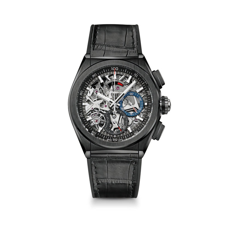 The Zenith Defy El Primero 21 features a black skeletonized dial with visible gears, high-frequency chronograph, and a black leather strap, displaying intricate mechanical details.