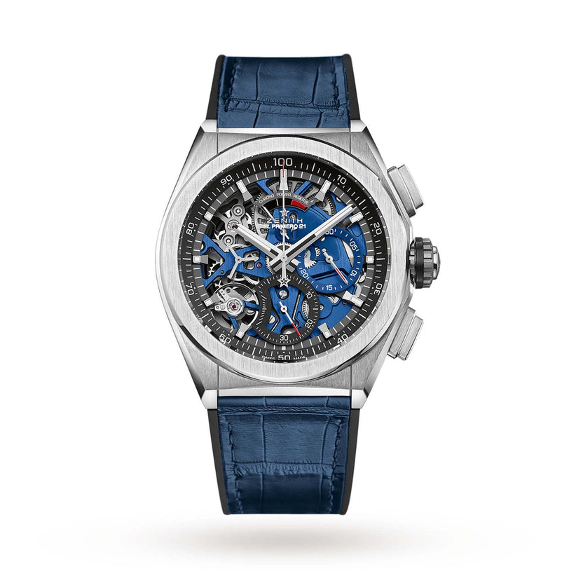 The Zenith Defy El Primero 21 is a luxury wristwatch with a titanium case, blue alligator strap, openworked blue and silver dial, visible gears, chronograph subdials, and the renowned El Primero 21 movement.