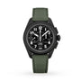 The Zenith Pilot Big Date Flyback is a black chronograph wristwatch featuring a black ceramic case, black dial with white numerals, two subdials, and a green fabric strap, displayed on a white background.