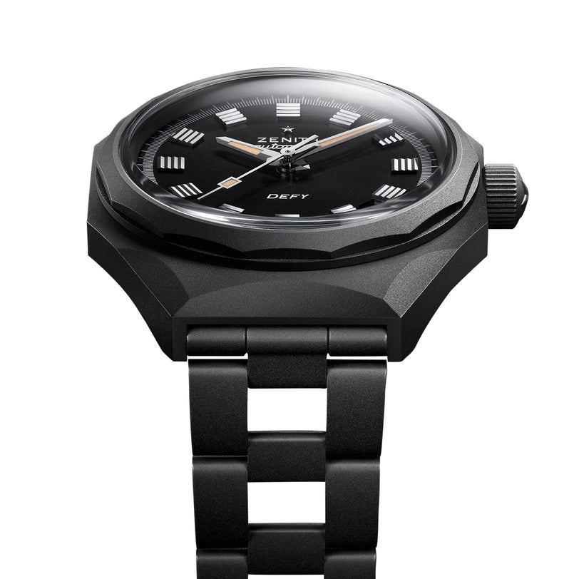 The Zenith Defy Revival Shadow wristwatch features a black design with a titanium case, round face, silver hour markers, and a metal link bracelet, displayed against a white background.