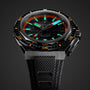 A close-up of the Zenith Defy Extreme Diver, a black dive watch featuring orange and turquoise markers, textured dial, automatic movement, black fabric strap, and impressive 500-meter water resistance.
