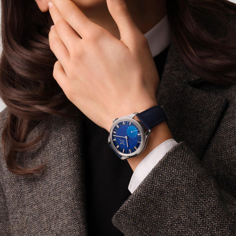 A person in a tweed blazer wearing the Zenith G.F.J Calibre 135, featuring a blue face and blue strap.