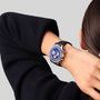 A person wearing the Zenith Chronomaster Original Lapis Lazuli, featuring a blue dial and black strap, rests their hand on the back of their neck.