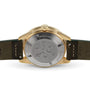 Back view of the Rado Captain Cook Automatic Bronze, showcasing its bronze case and engraved metal case back with seahorses, stars, technical details, and a green leather strap.