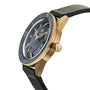 The Rado Captain Cook Automatic Bronze features a gold-tone finish with a black bezel, dark green leather strap, and visible crown, showcased at an angle against a white background.