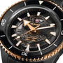 Close-up of the Rado Captain Cook High-Tech Ceramic wristwatch with a black and gold case, visible automatic movement, Nivachron™ hairspring, and 300m/1000ft water resistance shown on the dial.