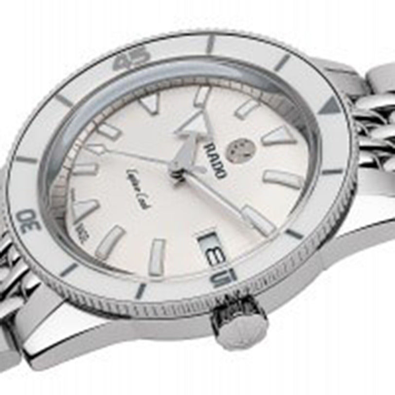 A close-up of the Rado Captain Cook Automatic wristwatch featuring a silver case, white dial, silver hour markers, modern features, and a date display at 3 o’clock.