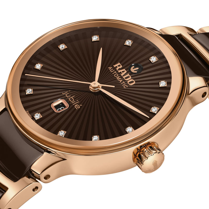 Close-up of the Rado Centrix Automatic Diamonds watch, featuring a brown dial with diamond hour markers, gold-tone case, high-tech ceramic accents, and a date display at 6 oclock.