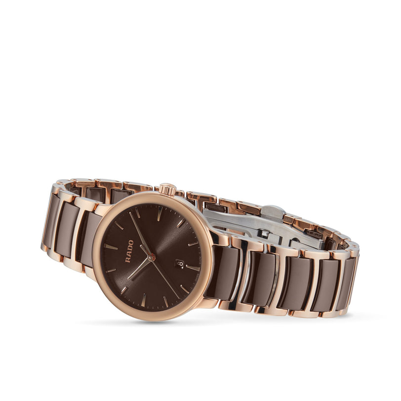 The Rado Centrix is a luxury automatic watch with a brown dial, date display, and a two-tone brown and rose gold metal bracelet.