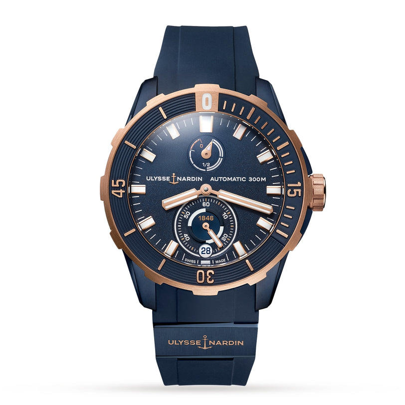 The Ulysse Nardin Diver 44 automatic watch features a navy blue face and strap, rose gold bezel, and multiple subdials with advanced silicium technology, elegantly displayed against a white background.