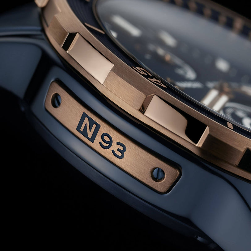 Close-up of the Ulysse Nardin Diver 44 wristwatch, showing a metal plate engraved with N93, a gold ridged bezel, and advanced silicium technology for high-precision timekeeping.