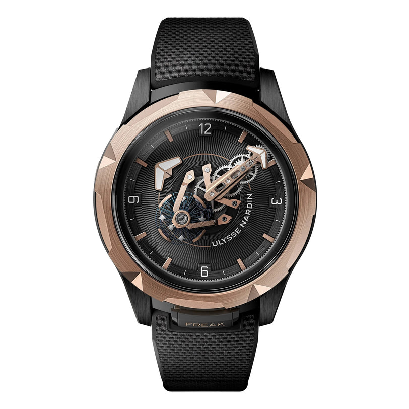 The Ulysse Nardin Freak ONE is a luxury mechanical watch with a black textured strap, black and gold case, and an exposed movement featuring an orbital carrousel tourbillon on the face.