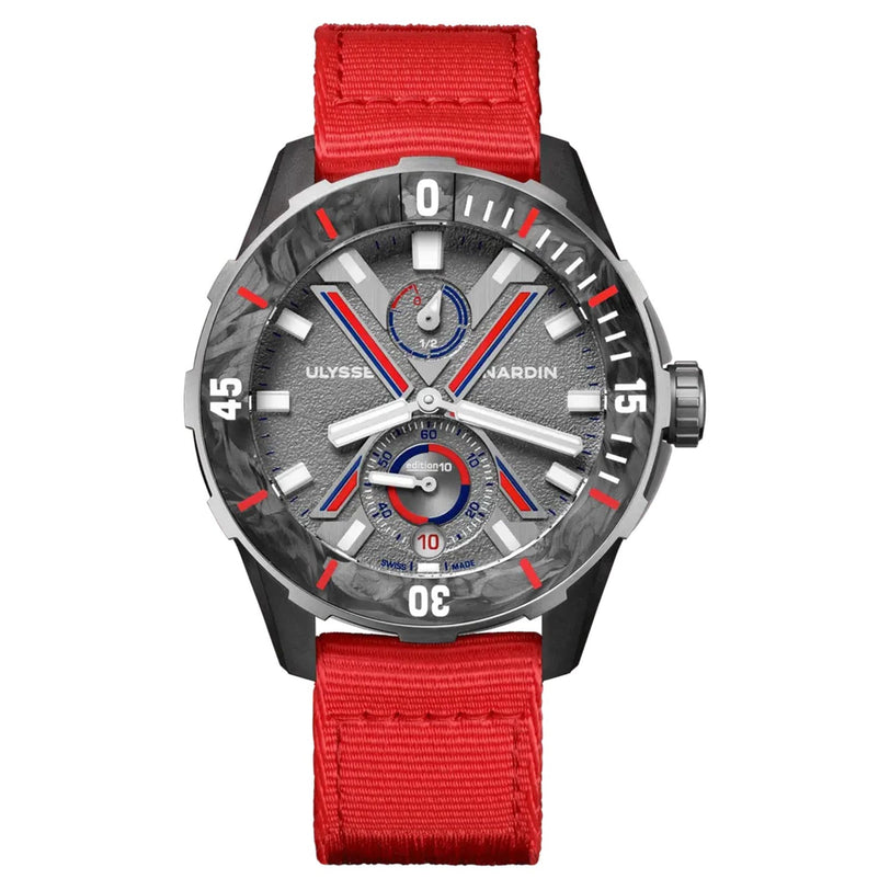 The Ulysse Nardin Diver NET Vendée Globe wristwatch features a red fabric strap, gray and silver textured dial, red and blue accents, and bold white markers at 15, 30, and 45 minutes—honoring the renowned sailing race.