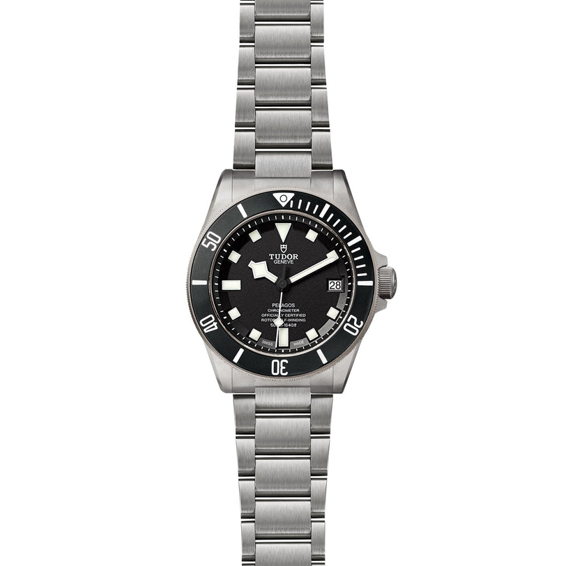 A TUDOR Pelagos stainless steel divers watch with a black rotating bezel, black dial, luminous markers, date window at 3 o’clock, and a link bracelet.
