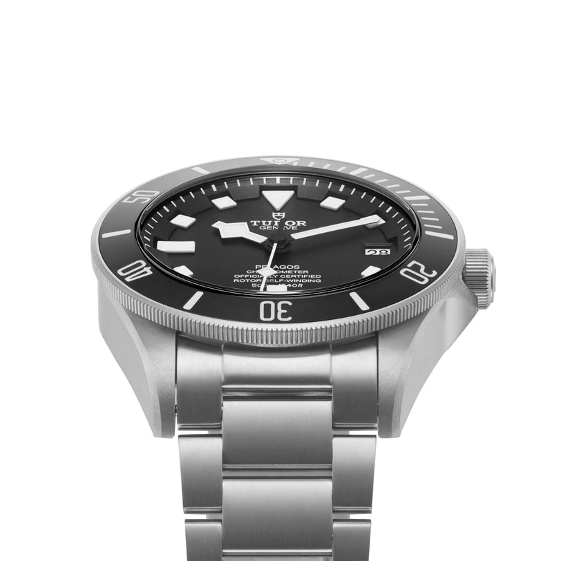 A TUDOR Pelagos stainless steel divers watch with a black dial, luminescent markers, rotating bezel, date window, and metal bracelet is angled to display its side and face.