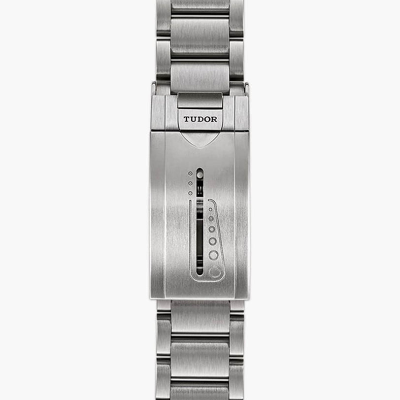 Close-up of a silver TUDOR Pelagos watch clasp featuring an adjustable sliding mechanism and engraved logo.