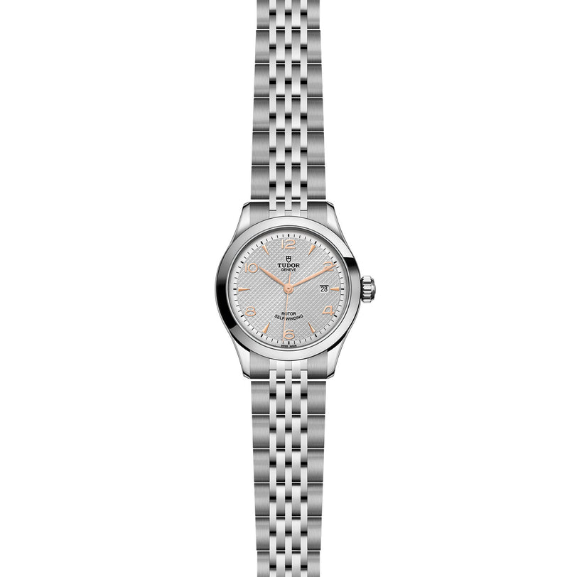 A TUDOR 1926 ladies wristwatch features a stainless steel bracelet, self-winding mechanical movement, silver patterned dial, and gold hour markers, shown on a white background.