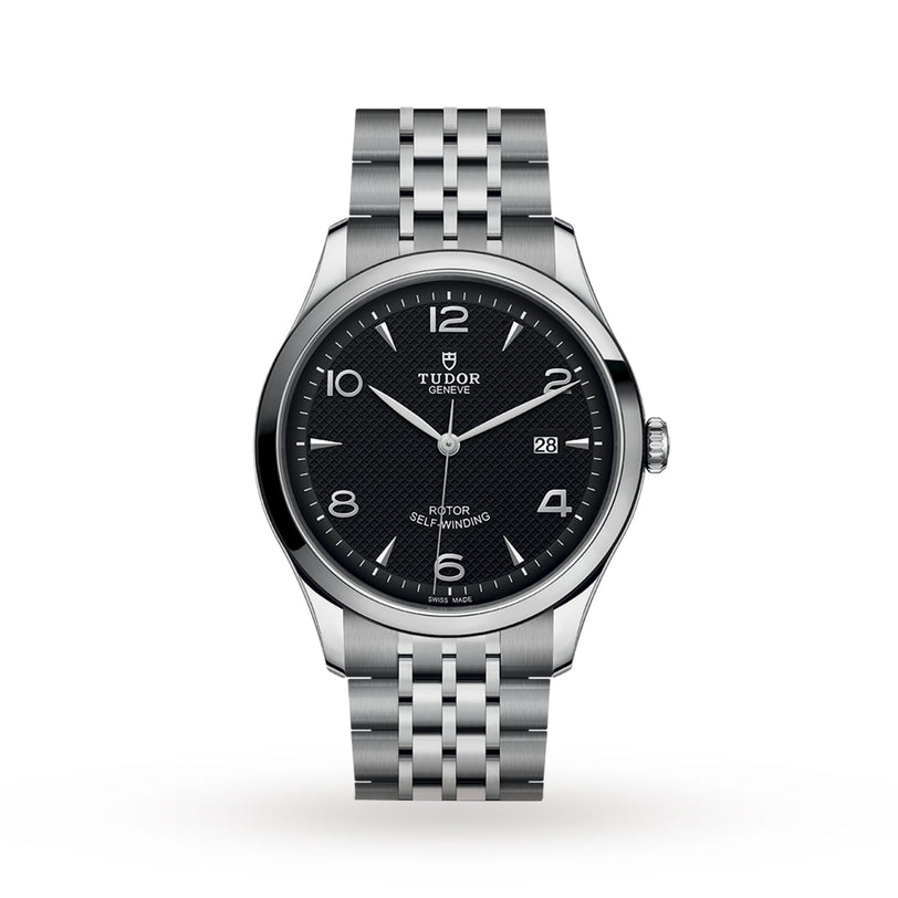 The TUDOR 1926 is a stainless steel wristwatch with a black textured dial, silver markers, date at 3 oclock, and a multi-link bracelet, all protected by a sapphire crystal lens.