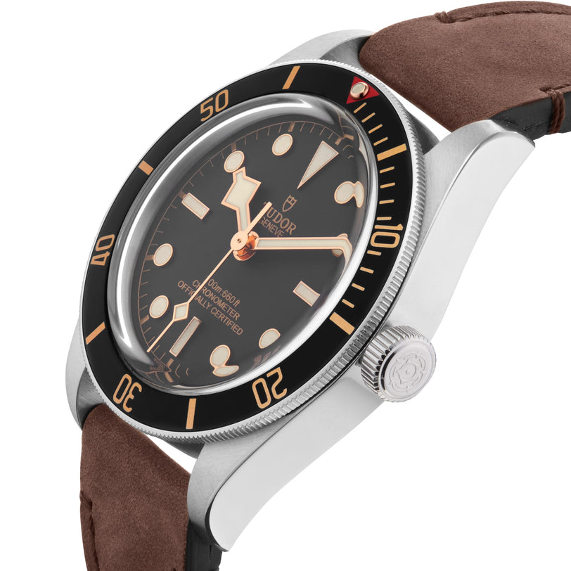 A close-up of the TUDOR Black Bay 58 wristwatch with a black dial, beige markers, brown leather strap, and stainless steel case, highlighting the vintage-inspired style of TUDOR’s renowned dive watches.