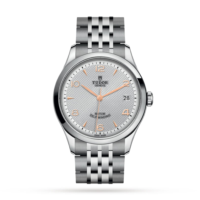 The TUDOR 1926 is a silver wristwatch featuring a textured white dial, gold hour markers, and a date window at 3 o’clock.