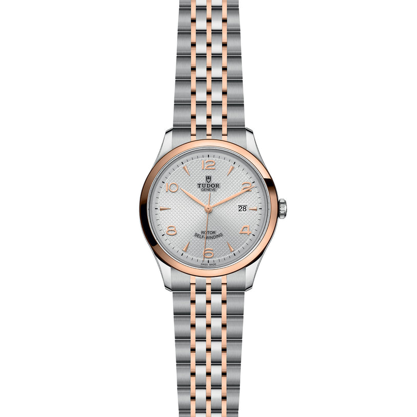 The TUDOR 1926 is a classic two-tone wristwatch with a silver and rose gold bracelet, round silver dial, gold hour markers, and a date window at 3 oclock—perfect for those who appreciate elegant mechanical watches.