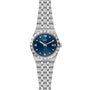 The TUDOR Royal is a silver automatic sport-chic watch featuring a blue dial with Roman numerals, diamond hour markers, date at 3 o’clock, and a stainless steel integrated bracelet.