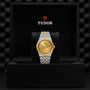 A TUDOR Royal wristwatch with a gold dial and two-tone stainless steel and gold bracelet, presented in an open black Tudor box—the Royal by TUDOR exemplifies automatic sport-chic style.