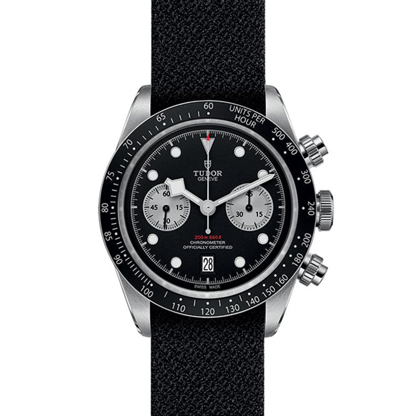 The TUDOR Black Bay Chrono wristwatch features a black dial with two subdials, a black fabric strap, and a silver case, offering classic chronograph functions and timeless style.