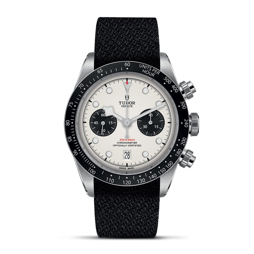 A TUDOR Black Bay Chrono wristwatch featuring a white dial, black subdials, tachymetric bezel, and a black fabric strap is displayed against a white background.
