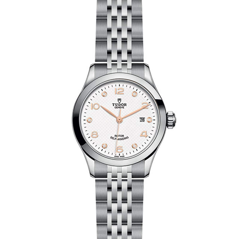 The TUDOR 1926 features a stainless steel case, white dial, silver hour markers, date at 3 o’clock, and metal link bracelet—an elegant tribute to TUDOR’s tradition of fine mechanical watches.