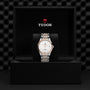The TUDOR 1926 wristwatch, featuring a silver and gold bracelet and a white dial, is displayed in an open black TUDOR box with the brand logo and name.