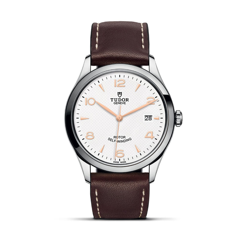 The TUDOR 1926 is a classic wristwatch featuring a white dial, silver bezel, brown leather strap, gold-tone hands and markers, plus a date window at 3 o’clock—ideal for mechanical watch enthusiasts.