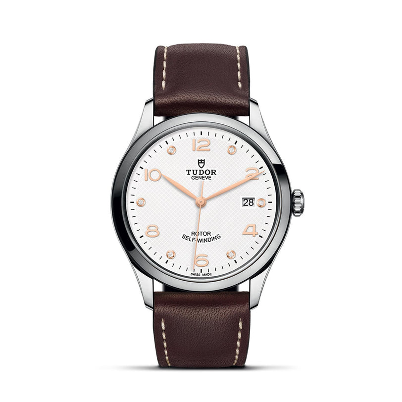 The TUDOR 1926 wristwatch features an elegant white dial, brown leather strap, silver case, gold hour markers, and a date display at 3 o’clock—capturing the timeless style of TUDOR.