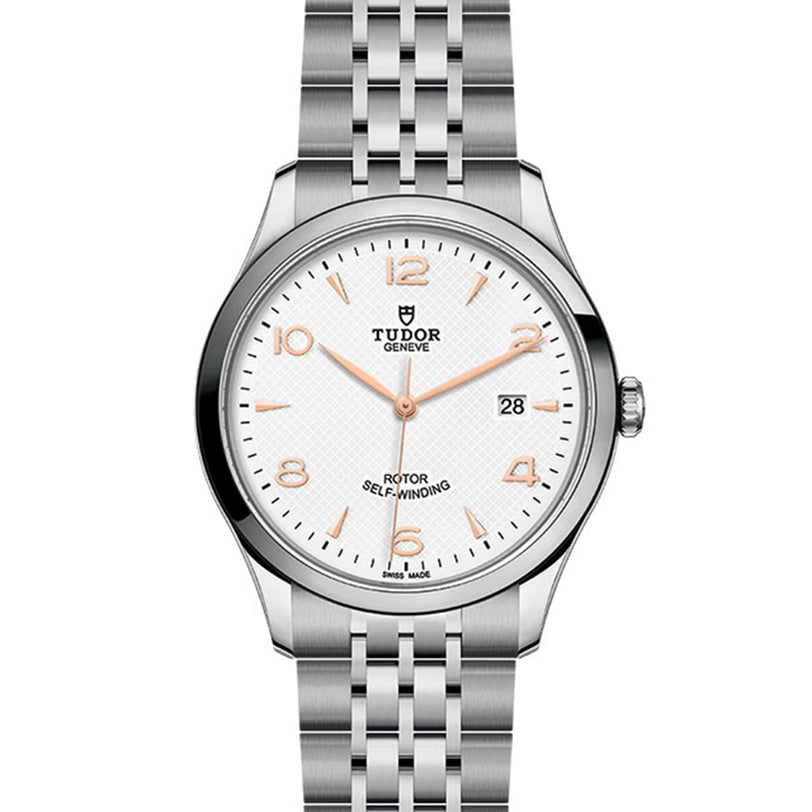 The TUDOR 1926 wristwatch features a silver case, white textured dial, gold-tone markers, and a date window at 3 o’clock.