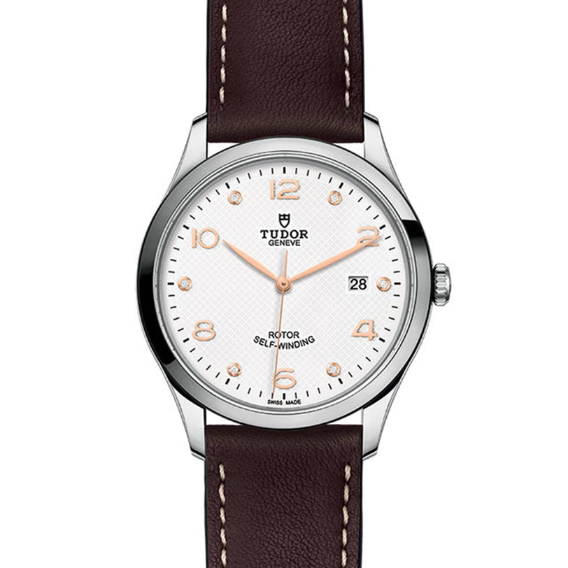 The TUDOR 1926 features a white textured dial, gold-tone numerals and markers, date at 3 o’clock, and a brown leather strap—a classic mechanical watch for elegant style lovers.