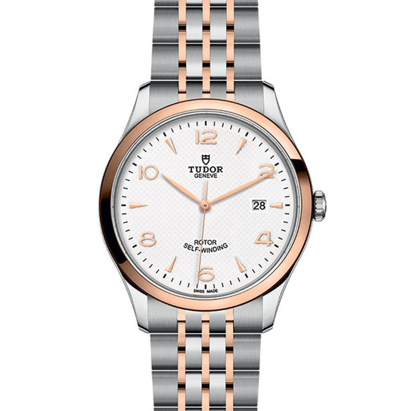 The TUDOR 1926 wristwatch features a silver and rose gold bracelet, white textured dial, gold hour markers, date display, and Rotor Self-Winding text—an elegant testament to TUDOR’s tradition of fine mechanical timepieces.