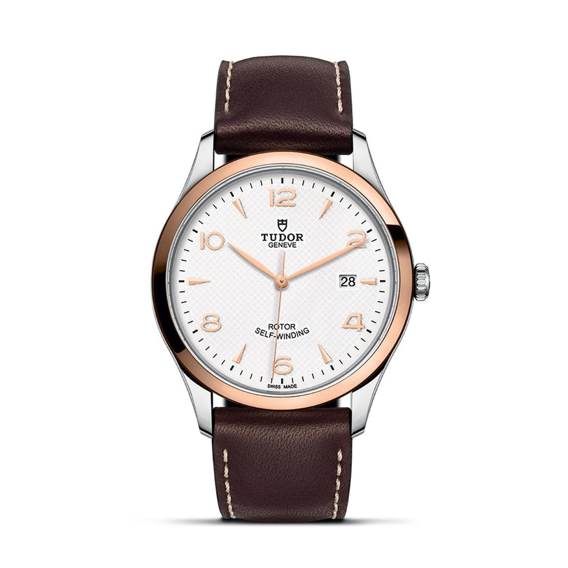 The TUDOR 1926 wristwatch features a white textured dial, gold hour markers, date display at 3 o’clock, and a brown leather strap with white stitching—a timeless choice for classic watch enthusiasts.