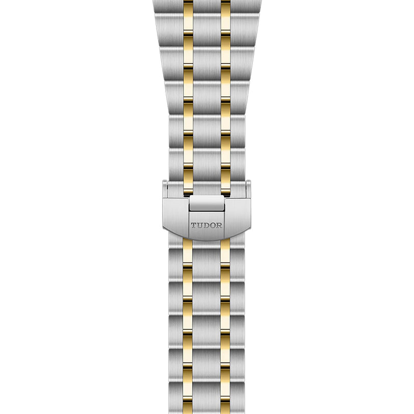The TUDOR Royal bracelet features a two-tone metal design with alternating silver and gold links, finished with a clasp engraved with the TUDOR logo, inspired by the Royal range.