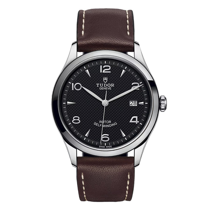 The TUDOR 1926 wristwatch features a black dial, brown leather strap, and silver casing, displaying the time 10:10.