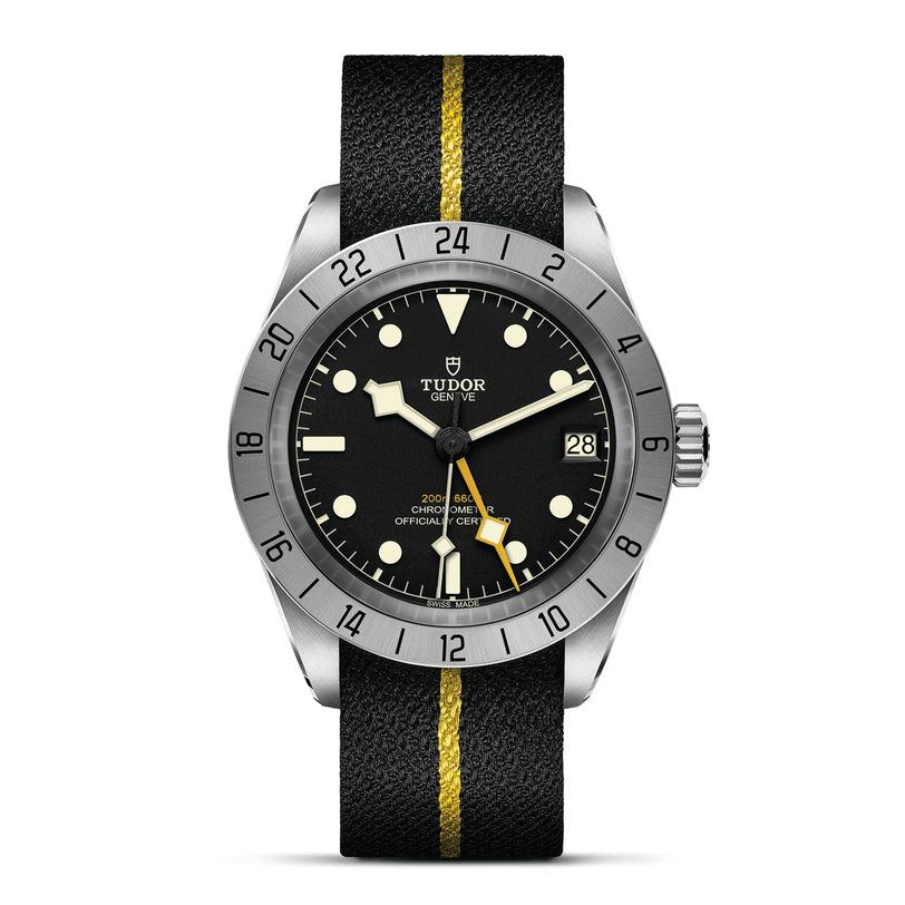The TUDOR Black Bay Pro is a neo-vintage wristwatch with a black dial, date window, stainless steel bezel, and a black leather strap accented by a yellow center stripe, inspired by the iconic Black Bay collection.