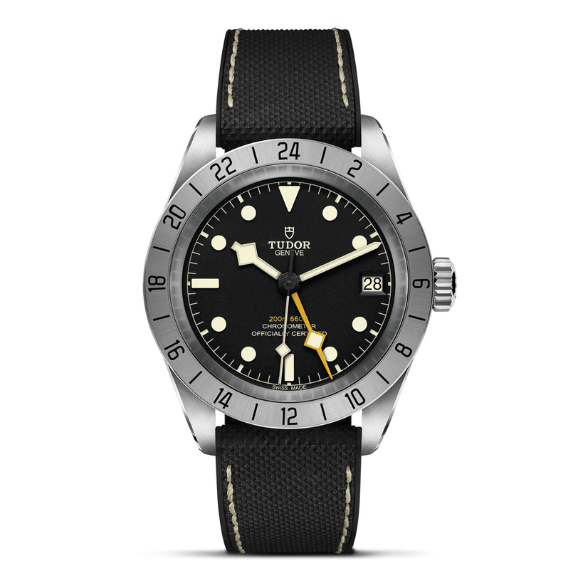 The TUDOR Black Bay Pro is a neo-vintage wristwatch inspired by classic Tudor divers, featuring a black dial, large luminescent markers, rotating bezel, date window at 3 o’clock, and a black textured strap with white stitching.