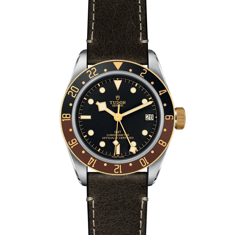 The TUDOR Black Bay GMT S&G features a black and gold bezel, black dial, leather strap, and a date display at 3 oclock.