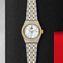 A two-tone TUDOR Royal wristwatch with a silver and gold bracelet, diamond hour markers, mother-of-pearl dial, and a gold bezel is displayed on a textured black and red background.