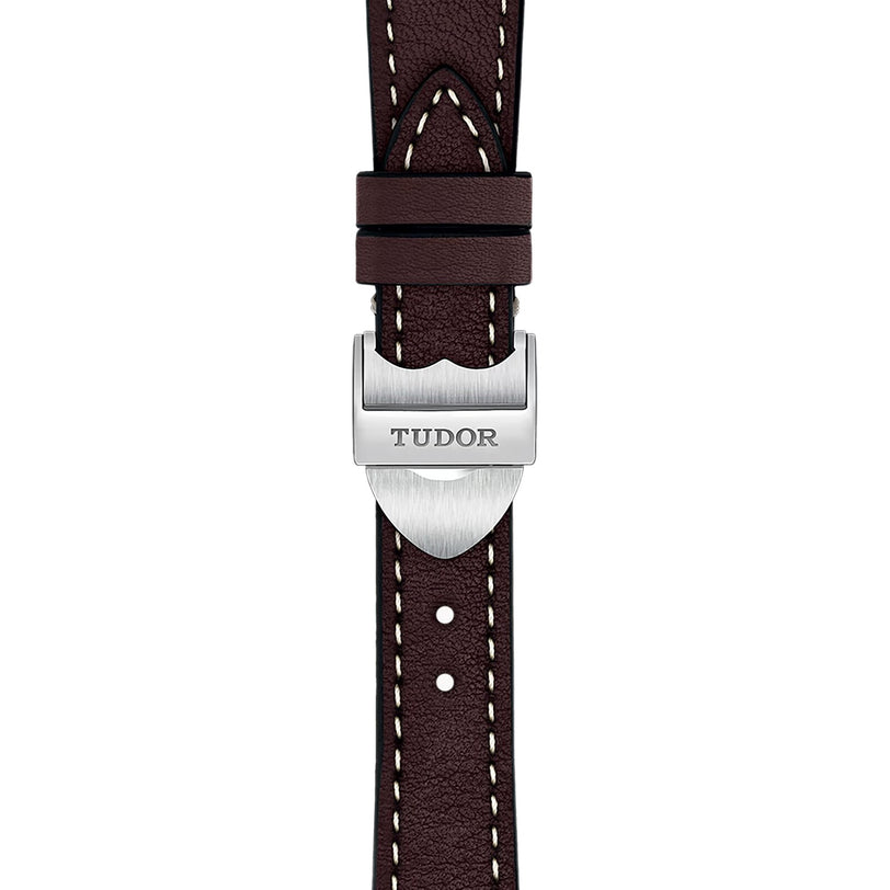 Close-up of a brown leather strap with white stitching and a silver TUDOR-engraved buckle, highlighting the classic craftsmanship found in TUDORs 1926 watches.