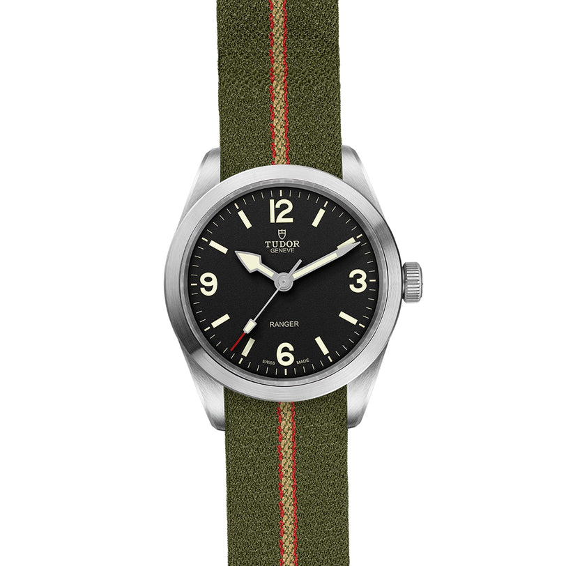 The TUDOR Ranger features a black dial with white numerals and an olive green jacquard strap with a bold red stripe, powered by the robust MT5402 movement.